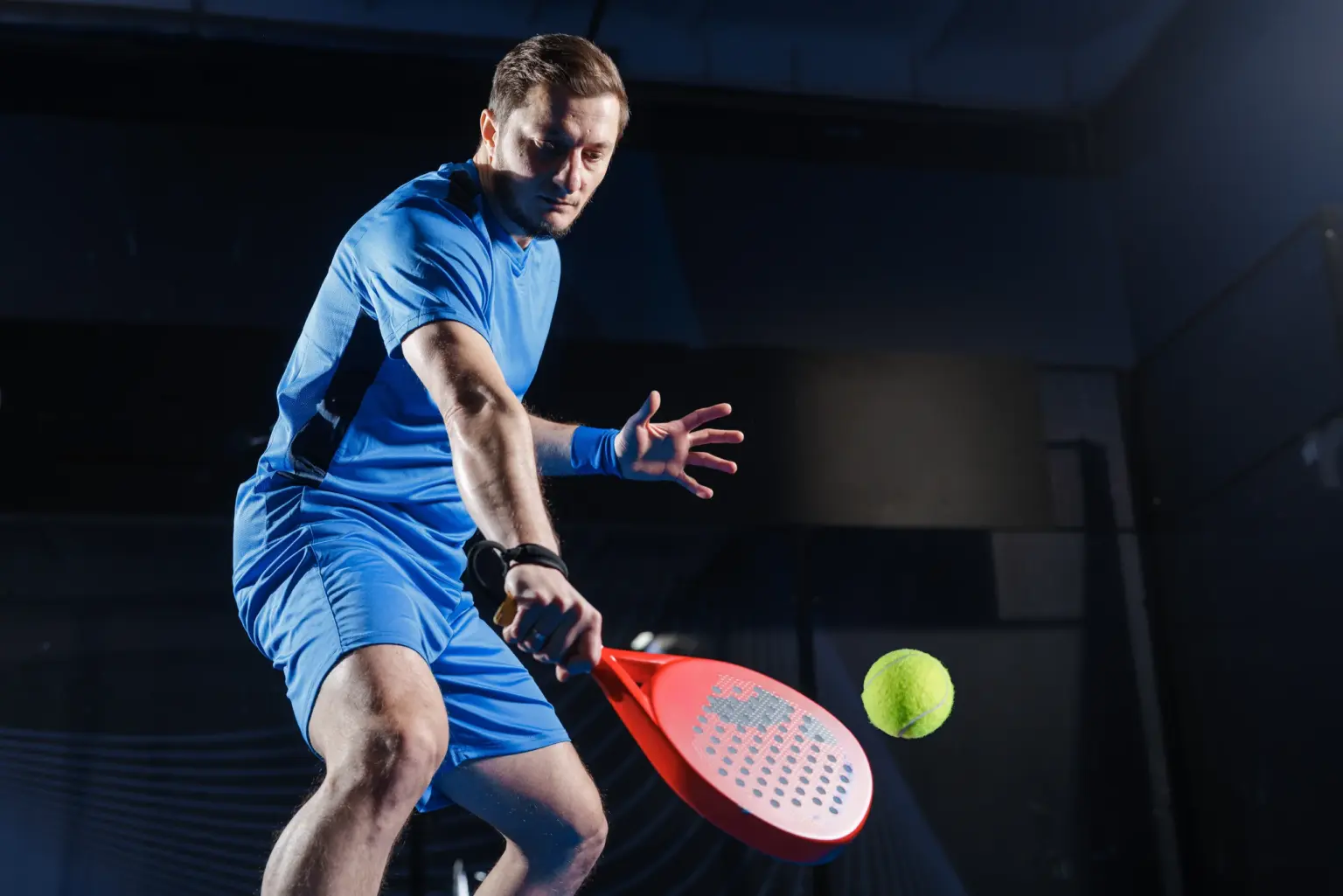 Einzelner Spieler beim Schlag auf dem Padelcourt